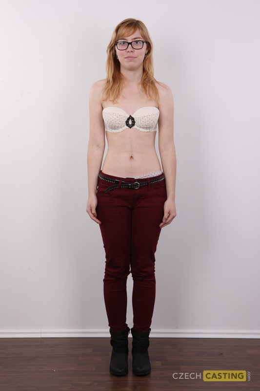 Amateur girl with red hair gets completely naked while wearing her glasses