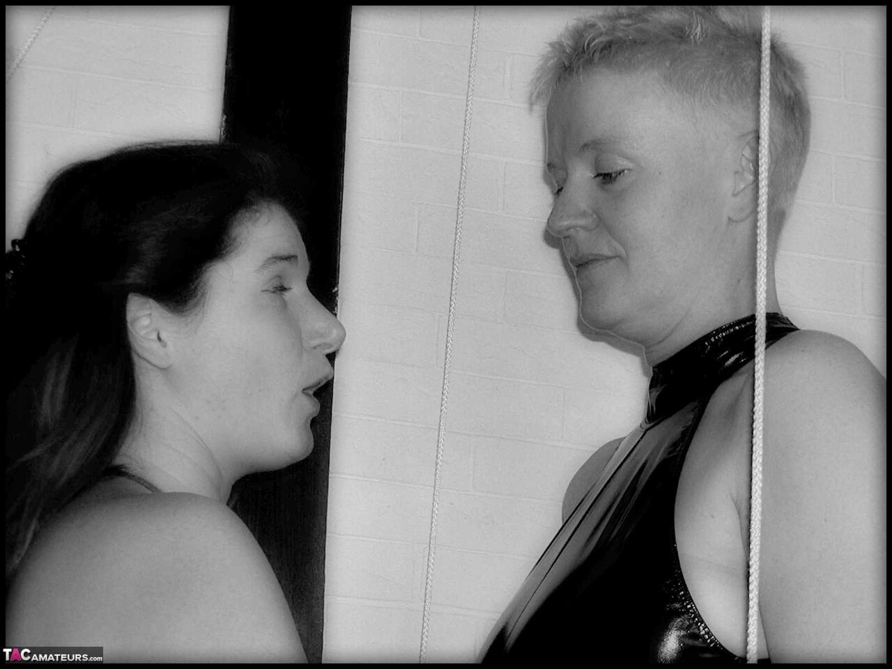 Tall older woman with short blonde hair engages in lesbian play with a girl
