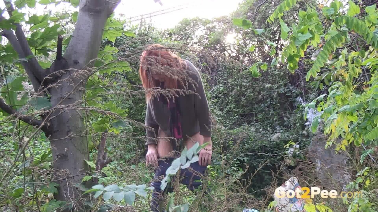 Skinny redhead Liza ducks into the bushes for an urgent piss