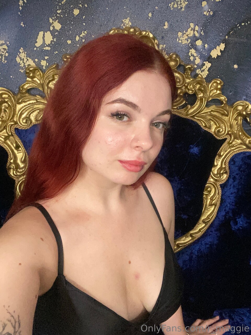 Sexy redhead holds the handle of a huge dildo while remaining clothed