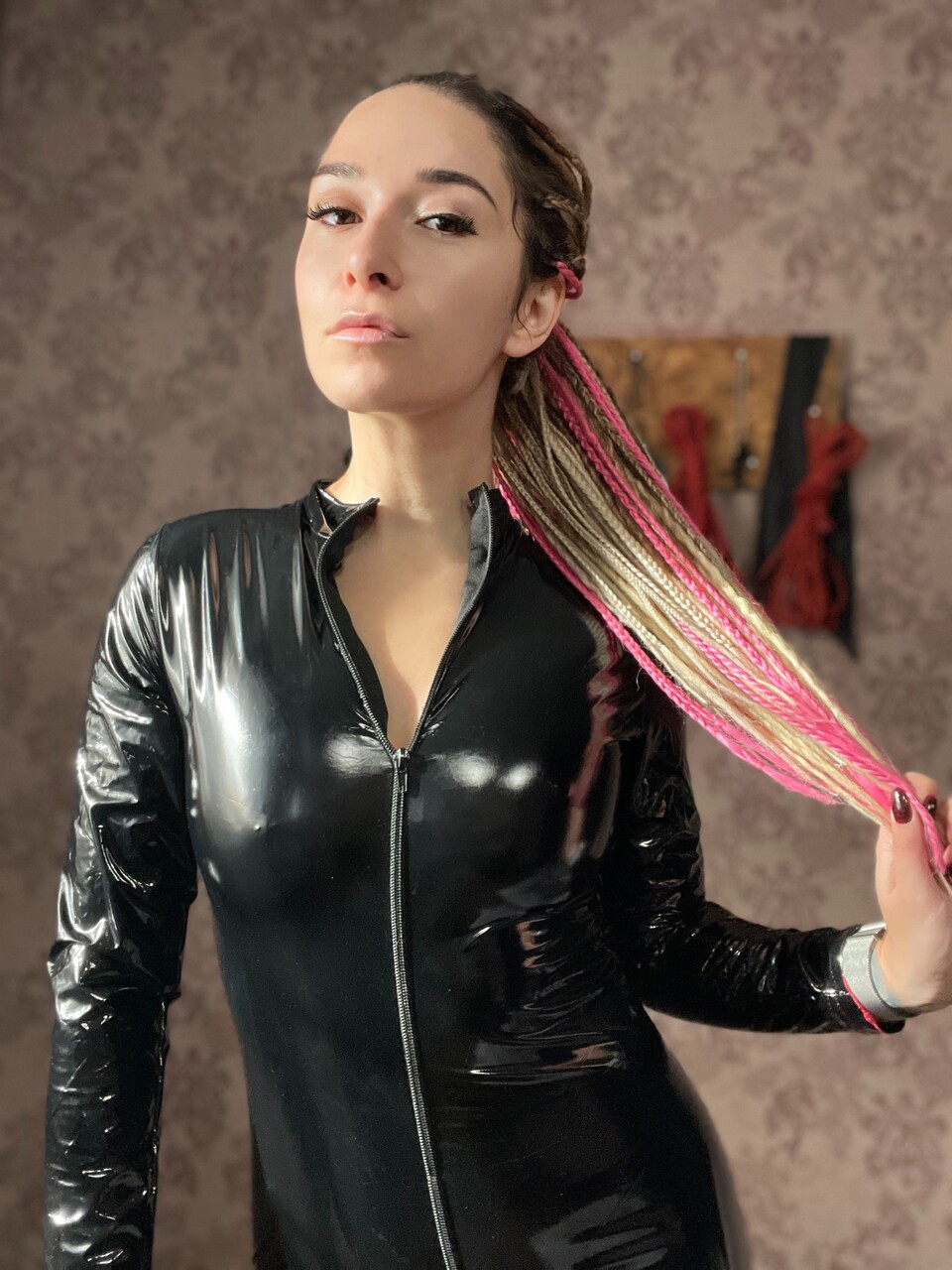 Solo girl with red lips uncovers her natural tits before wearing a fetish outfit