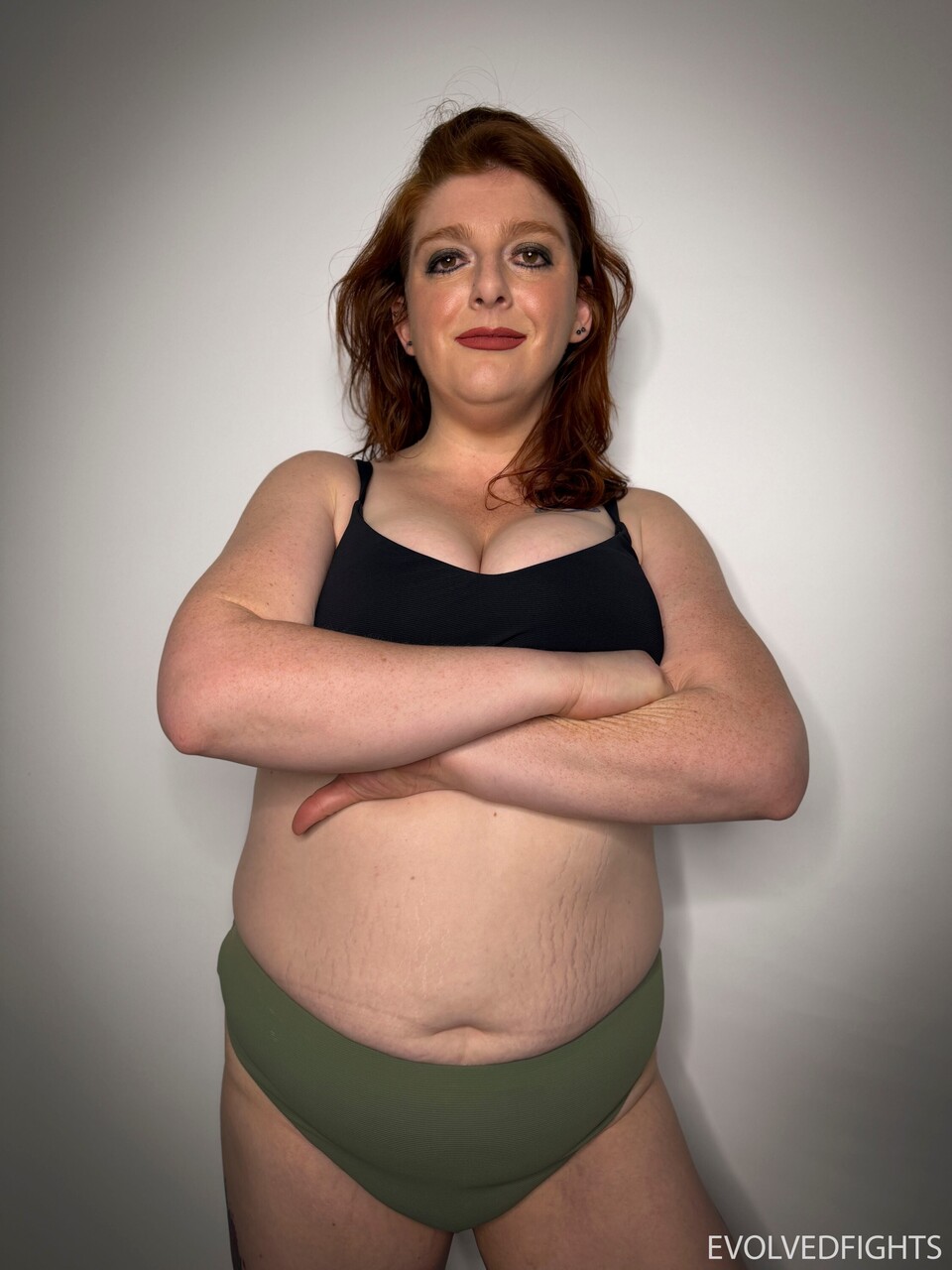 Chubby redhead dominates a male wrestler during a wrestling match