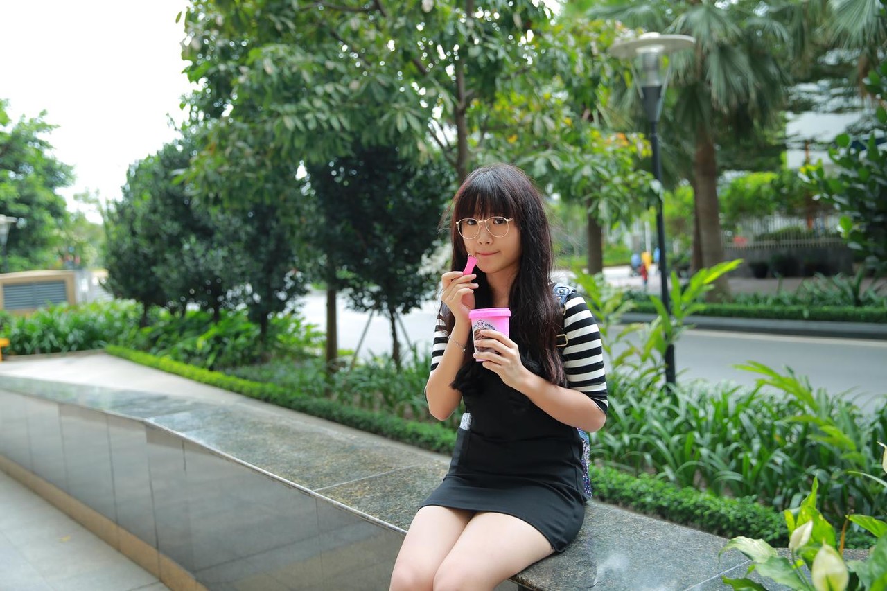 Short Asian model with a hat posing in her lovely outfit in public