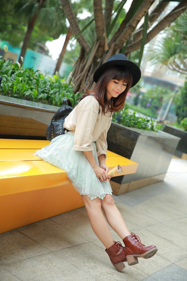 Short Asian model with a hat posing in her lovely outfit in public