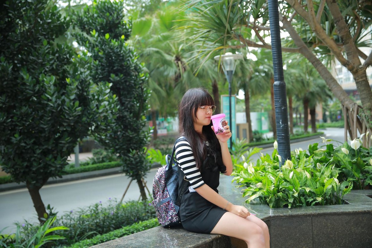Short Asian model with a hat posing in her lovely outfit in public