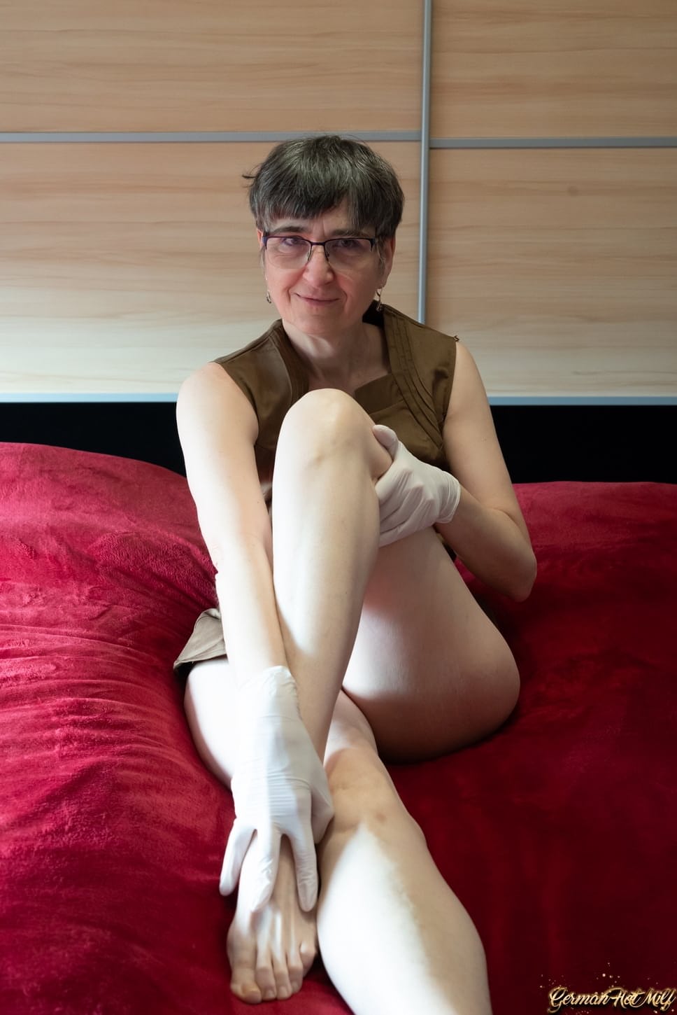 Mature lady HotMilf wears glasses while masturbating in white gloves