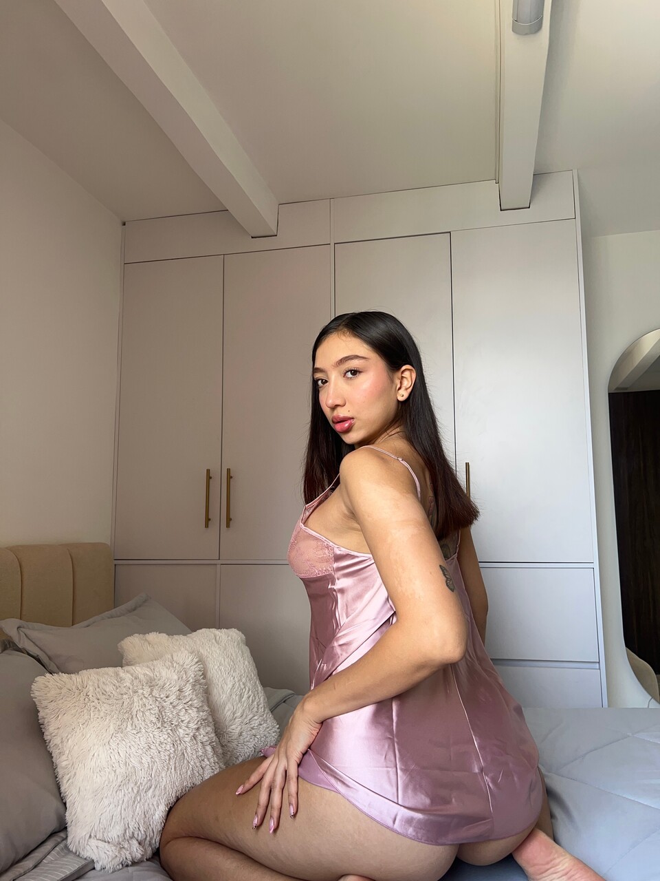 Beautiful brunette shows her hot ass in satin lingerie during a non-nude shoot