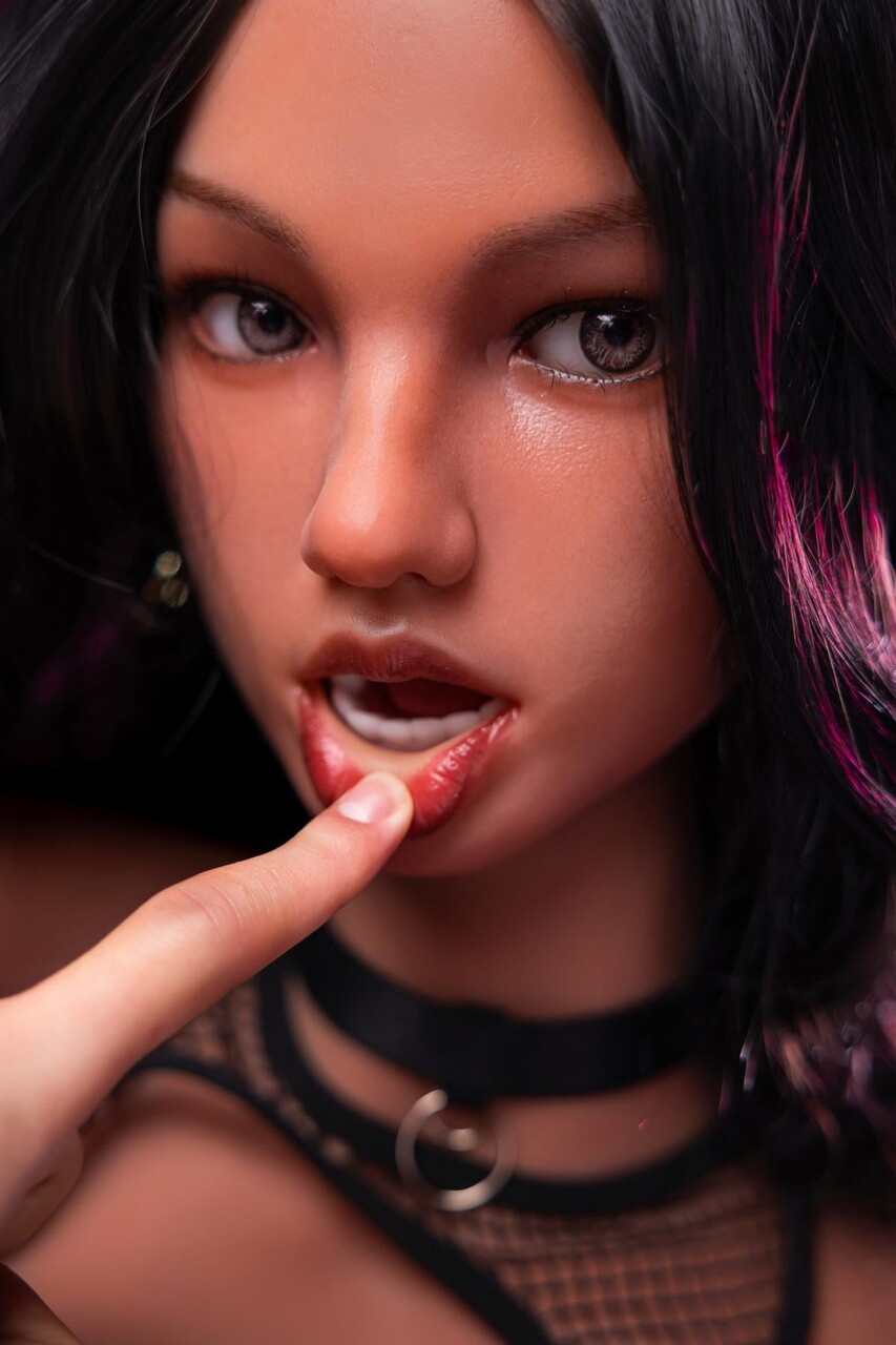 Beautiful sex doll with long dark hair and a phat ass gets naked on a sofa