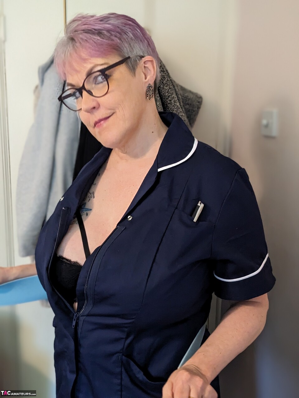Older nurse Layla Bird removes her uniform before masturbating on a bed