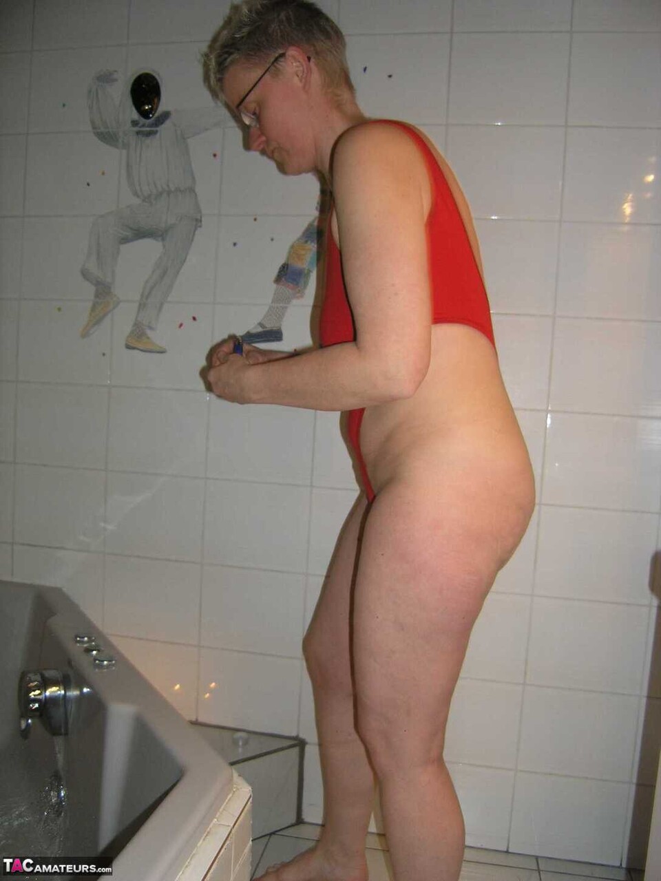 Mature amateur Tiffany Pearl takes a bath while wearing glasses and a red swimsu