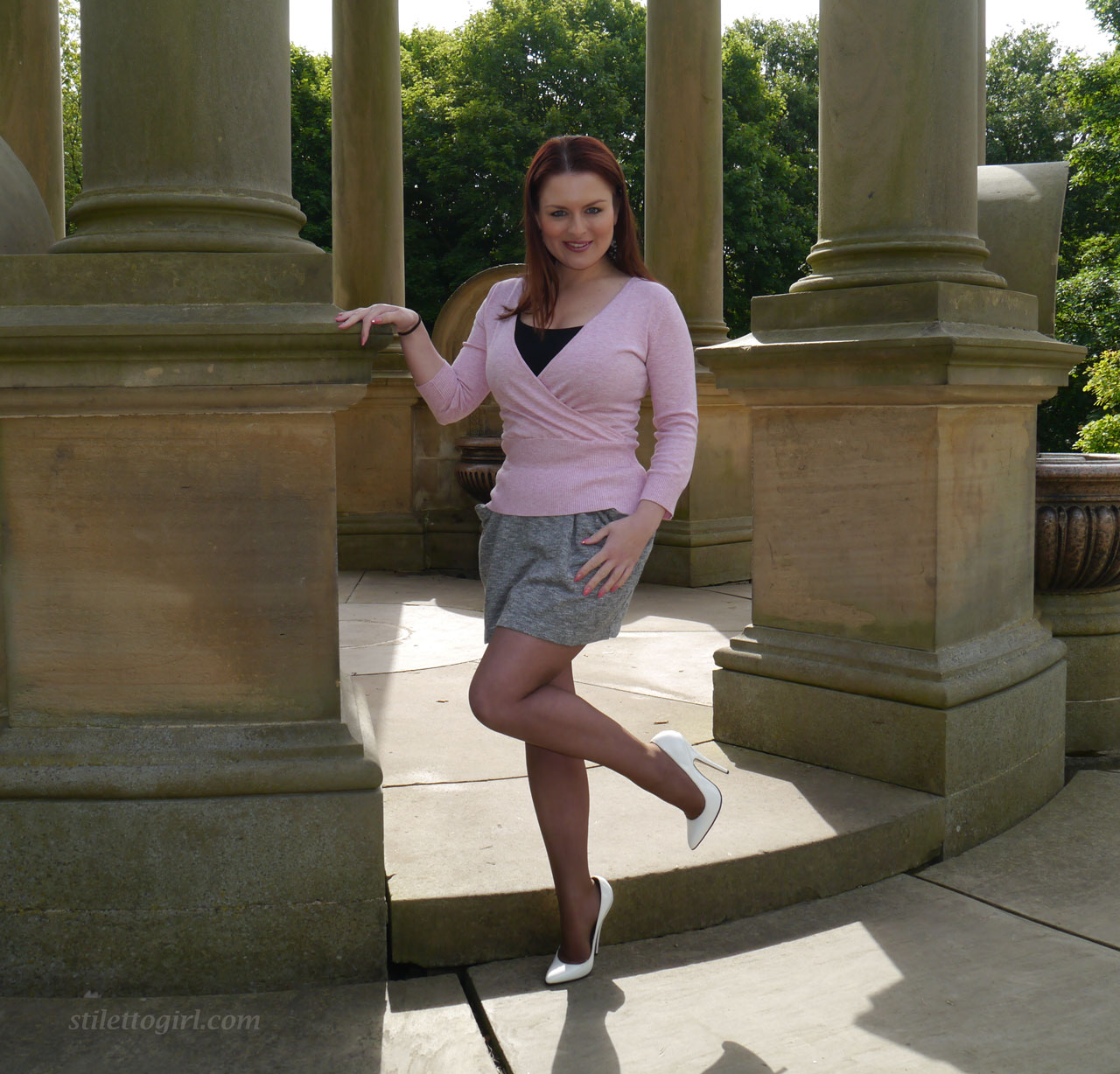 Redhead model showcases her hot legs in a short skirt and high heels