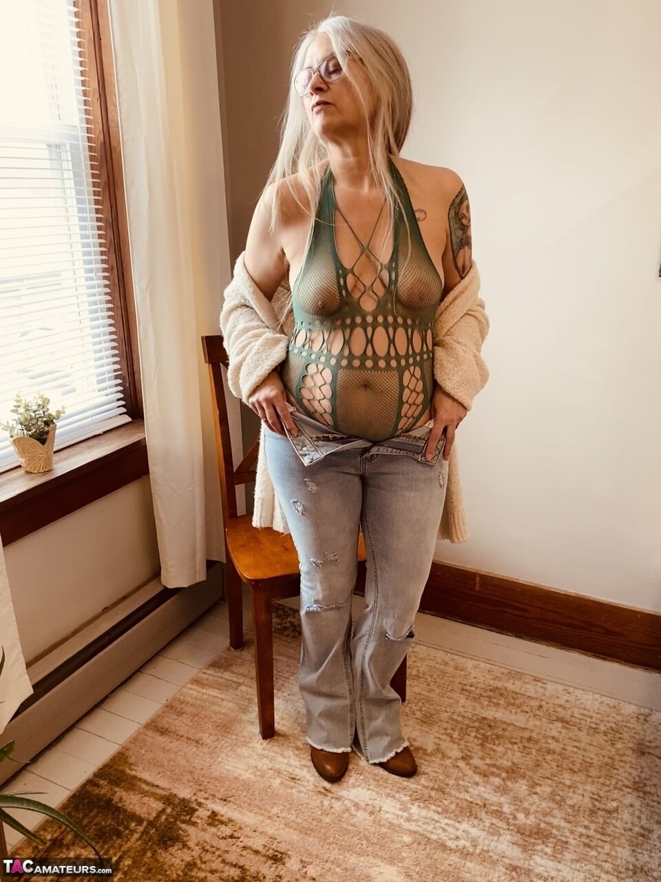 Older amateur piles up her hair in pigtails while getting naked on a bed