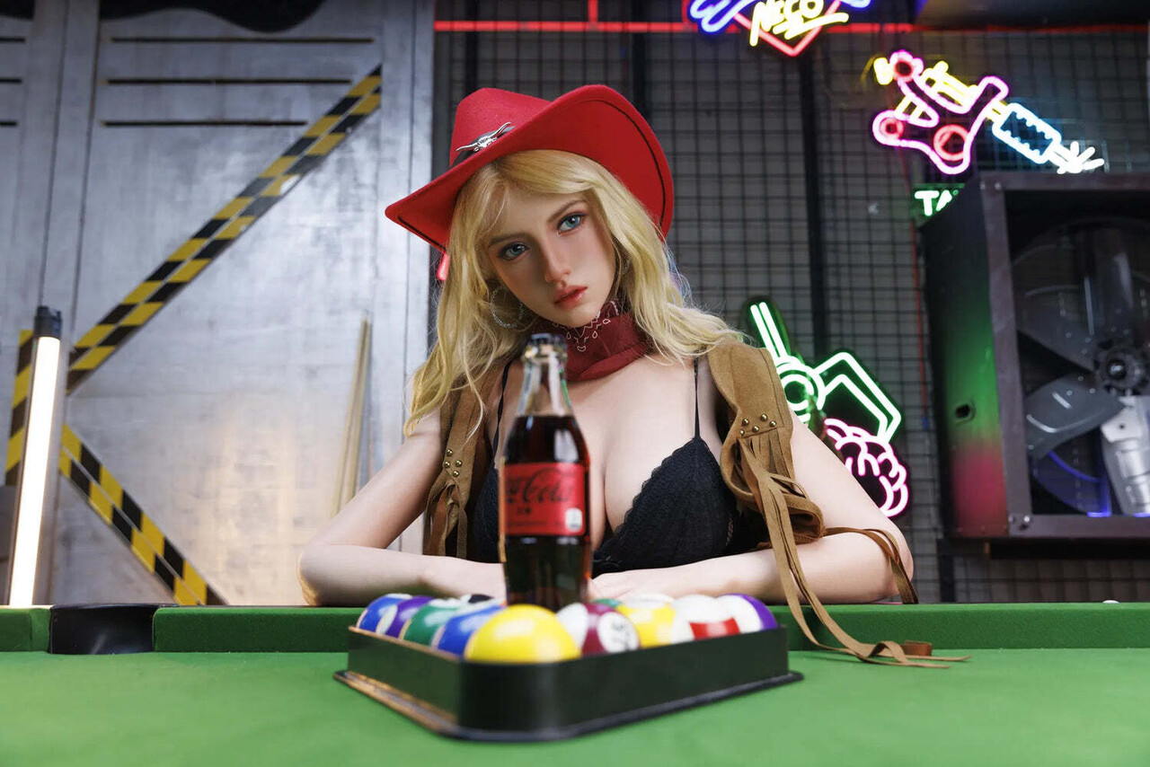 Sexy blonde doll dons a red cowboy hat while stripping to her boots
