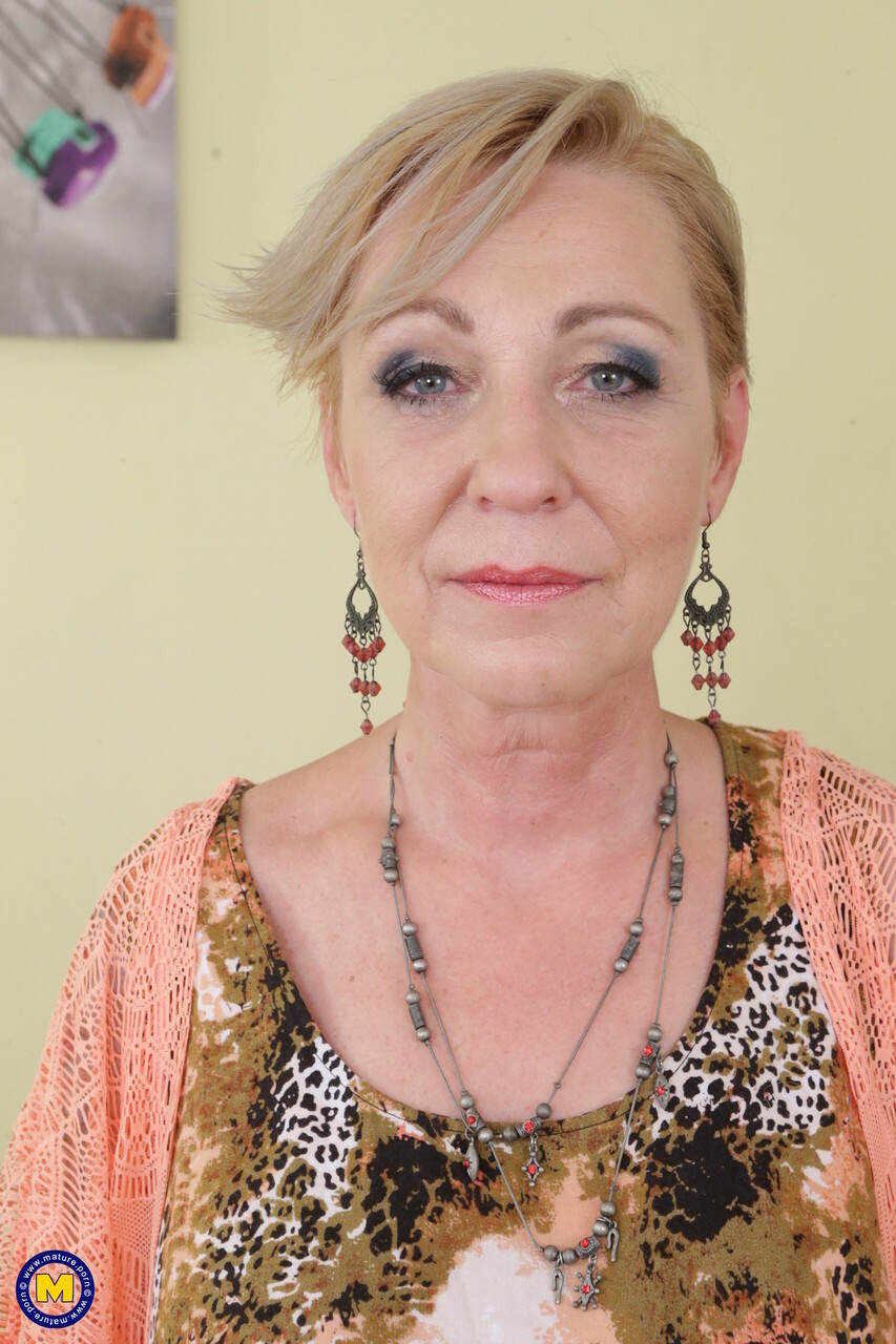 Mature blonde with a big natural tits masturbating on a round chesterfield