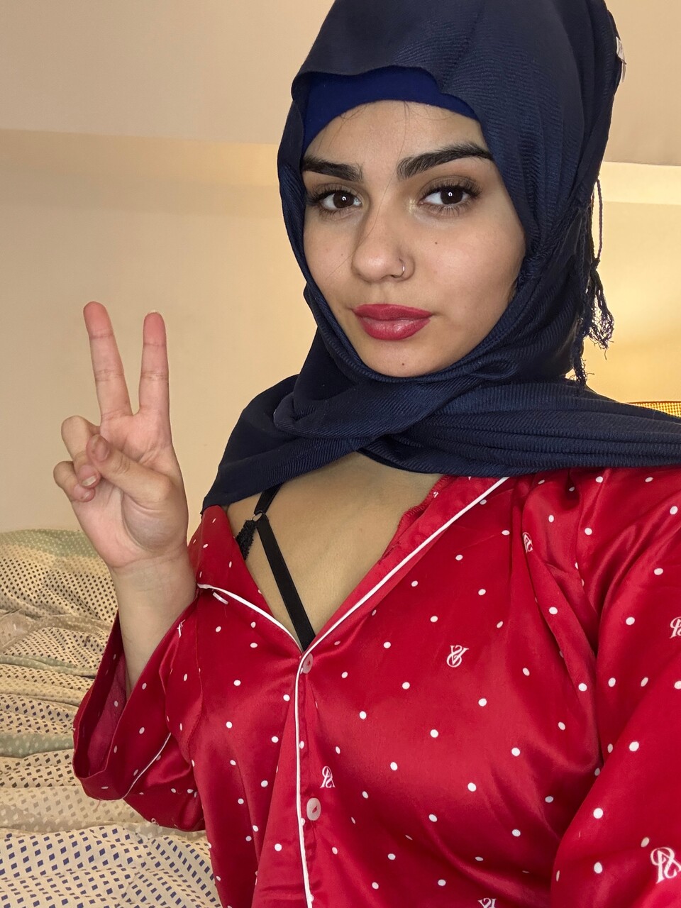 Solo model licks her feet while wearing a hijab in a black brassiere