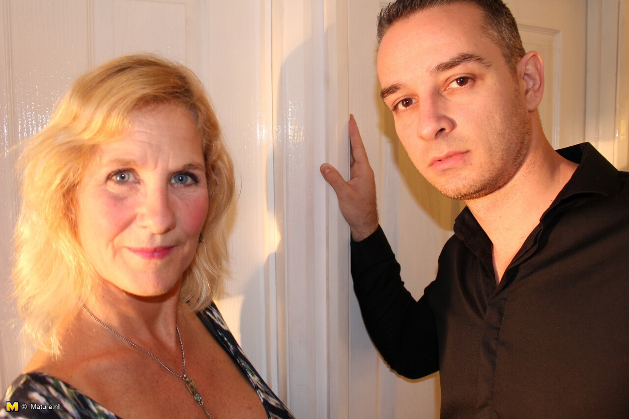 Mature blonde woman exposes her boobs while seducing a younger man