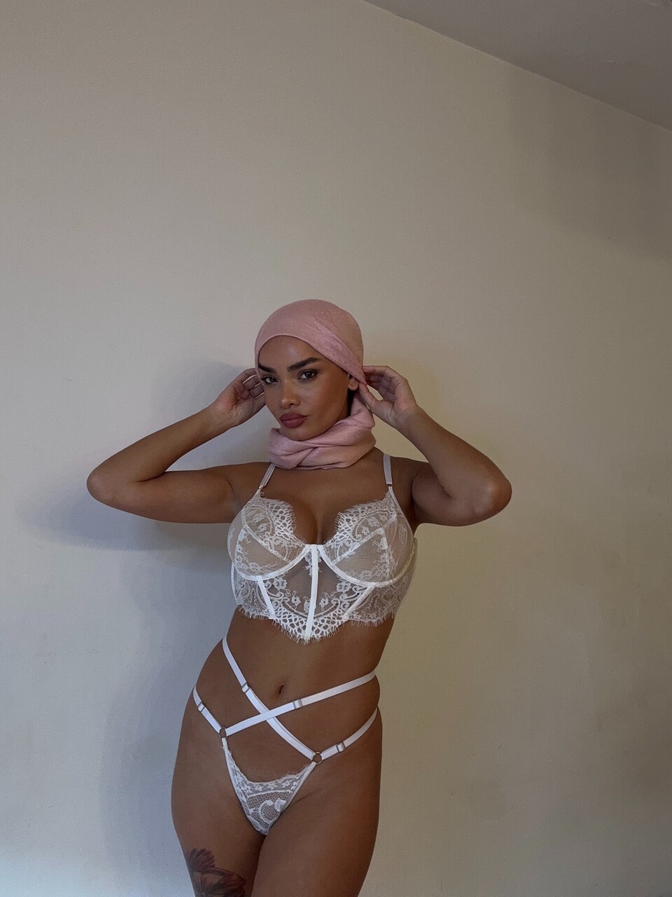 Solo model takes selfies while wearing a black hijab over lingerie