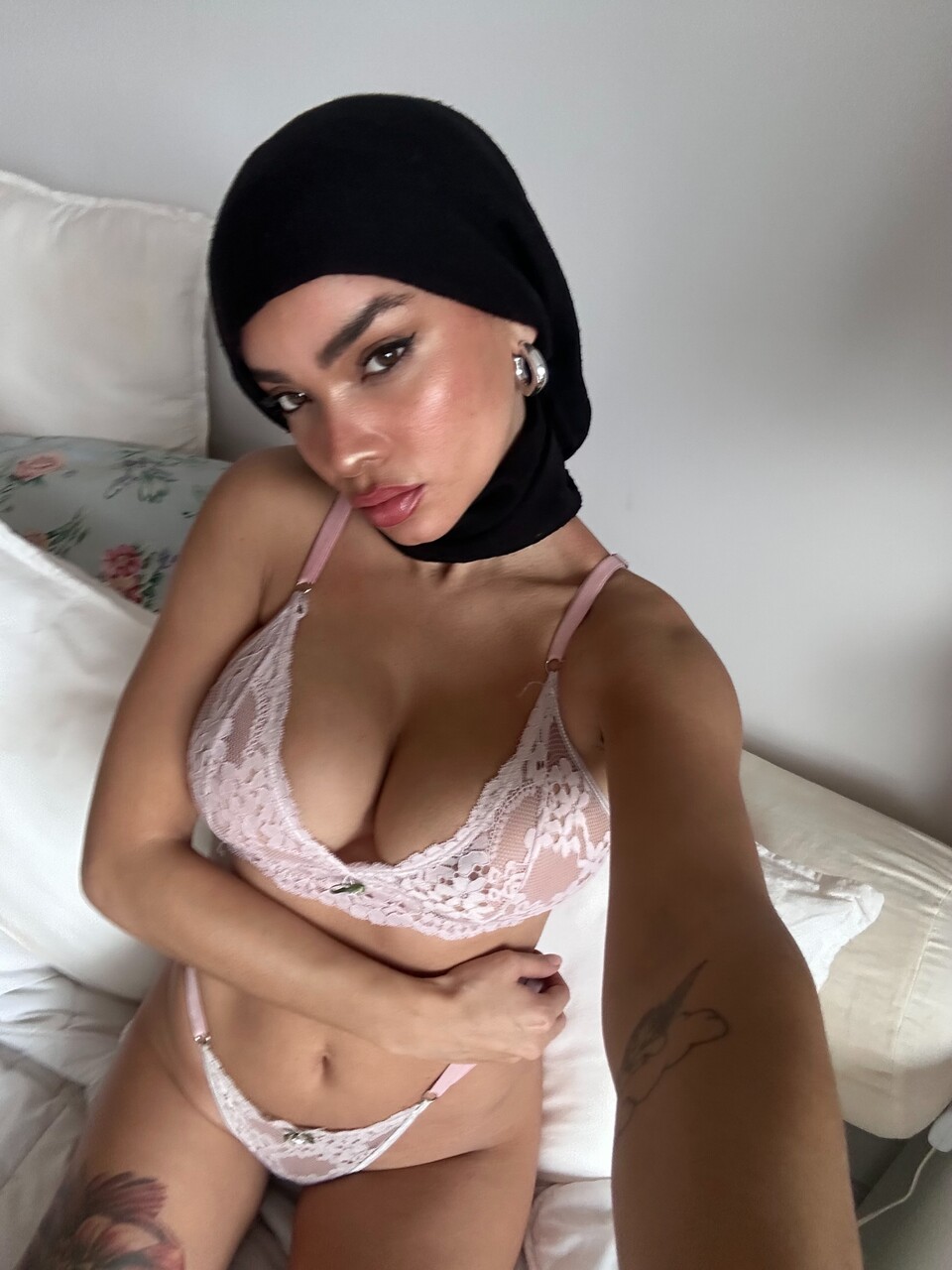 Solo model takes selfies while wearing a black hijab over lingerie