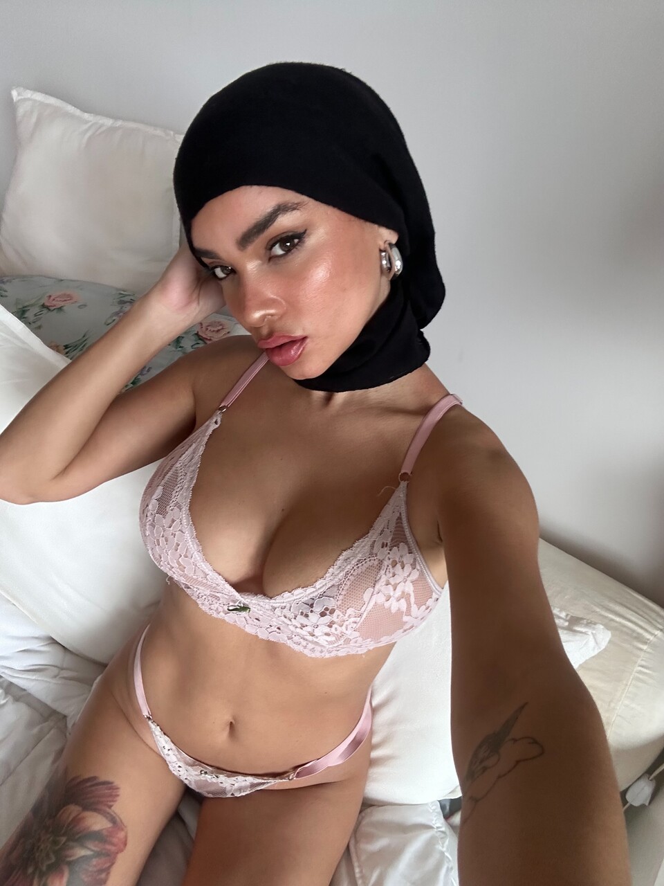 Solo model takes selfies while wearing a black hijab over lingerie