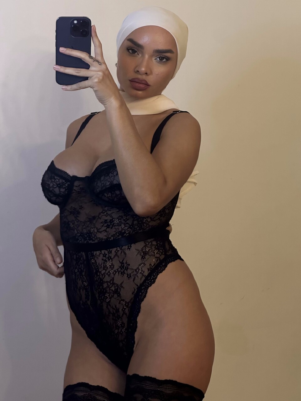 Solo girl takes selfies while wearing a black bodystocking and lingerie