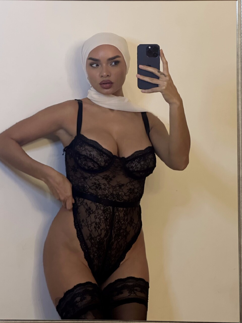 Solo girl takes selfies while wearing a black bodystocking and lingerie