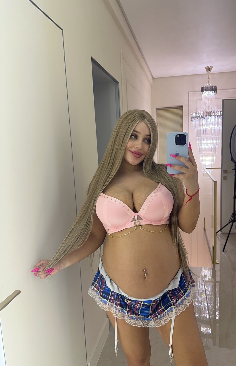 Pregnant solo girl takes selfies in a pink brassiere and plaid panties