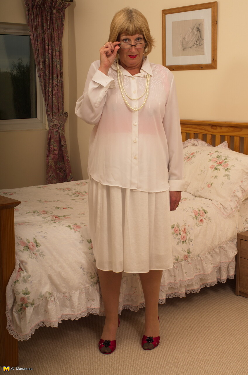Older blonde woman works her tits free of a blouse in a tempting fashion