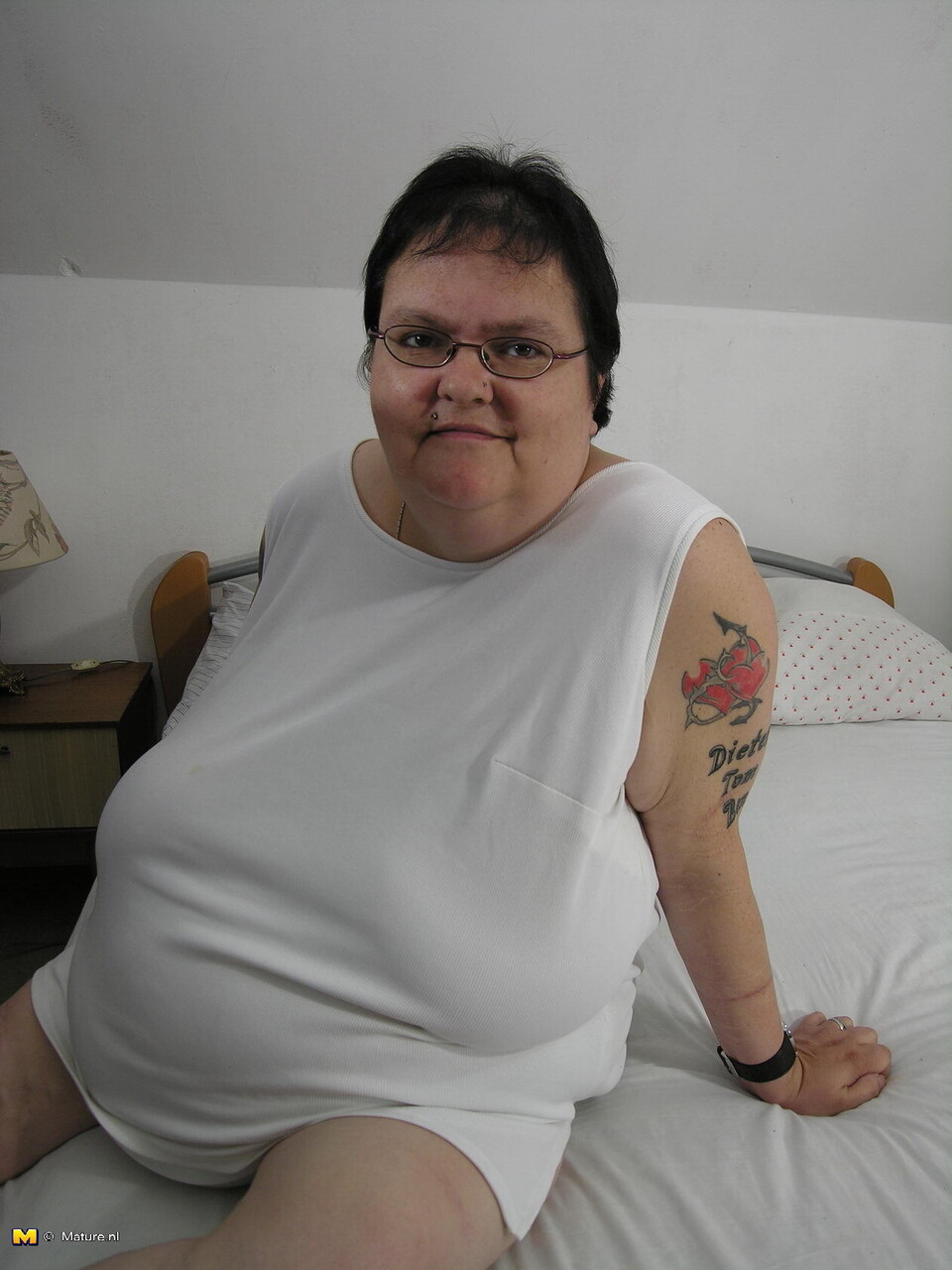 Mature fatty with tattoos sports glasses while masturbating with a vibrator