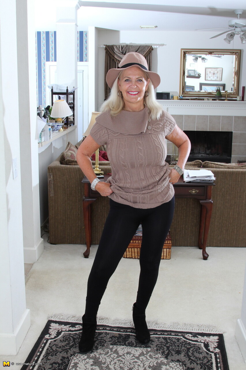 Older blonde exposes her natural tits and snatch in a thong and fedora