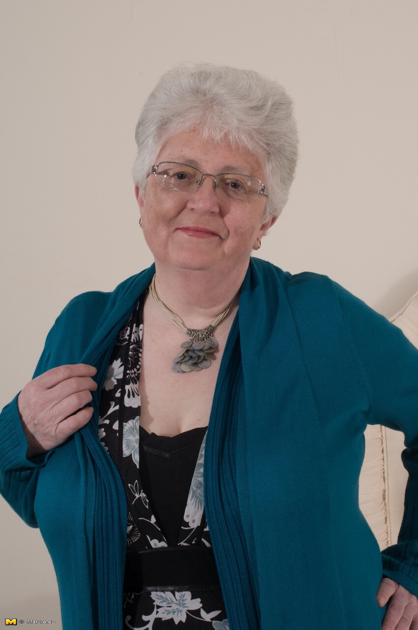 Old woman takes off her glasses and clothing to go topless in her underwear