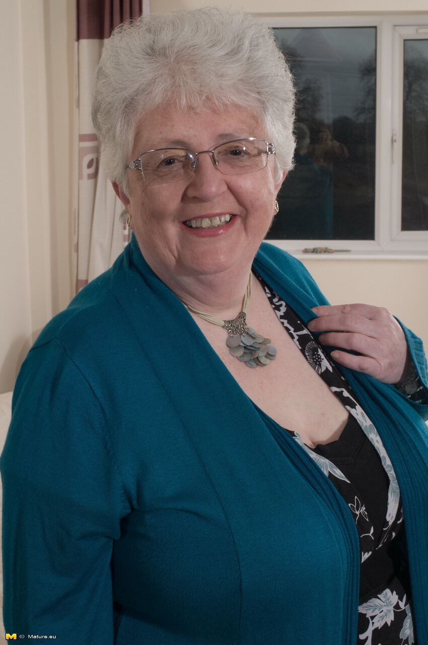 Old woman takes off her glasses and clothing to go topless in her underwear