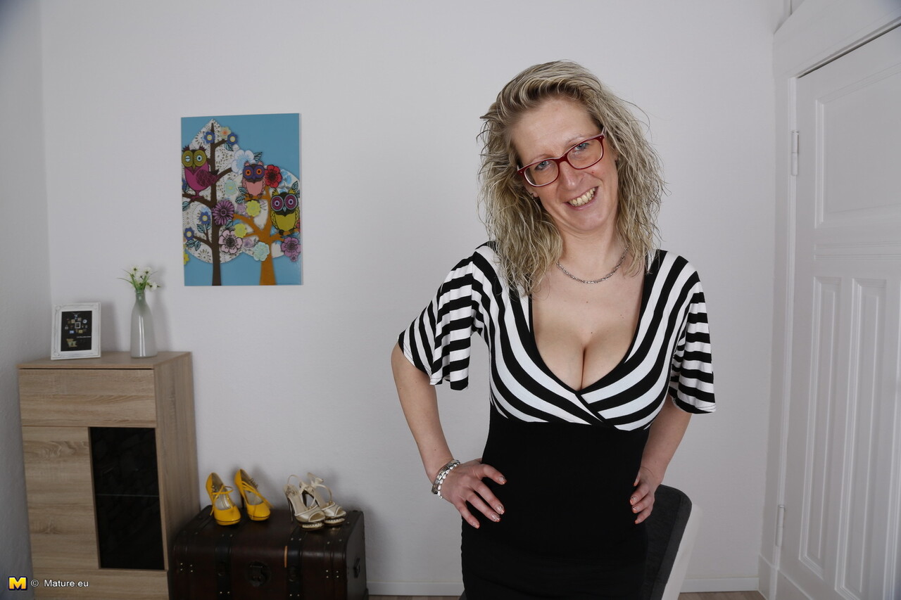 Older blonde woman licks her big boobs while wearing glasses and hose