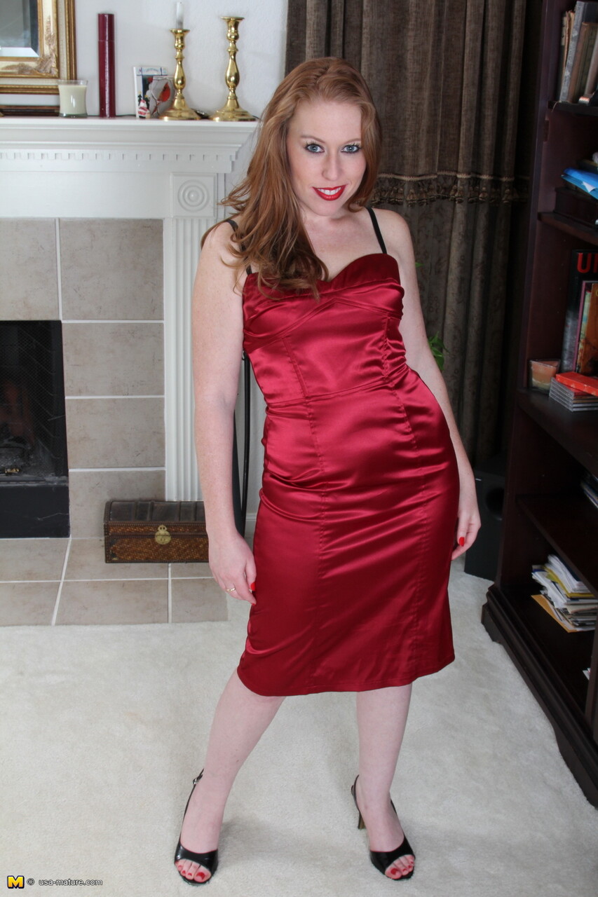 Thick redhead with red lips uncovers her small tits while getting undressed