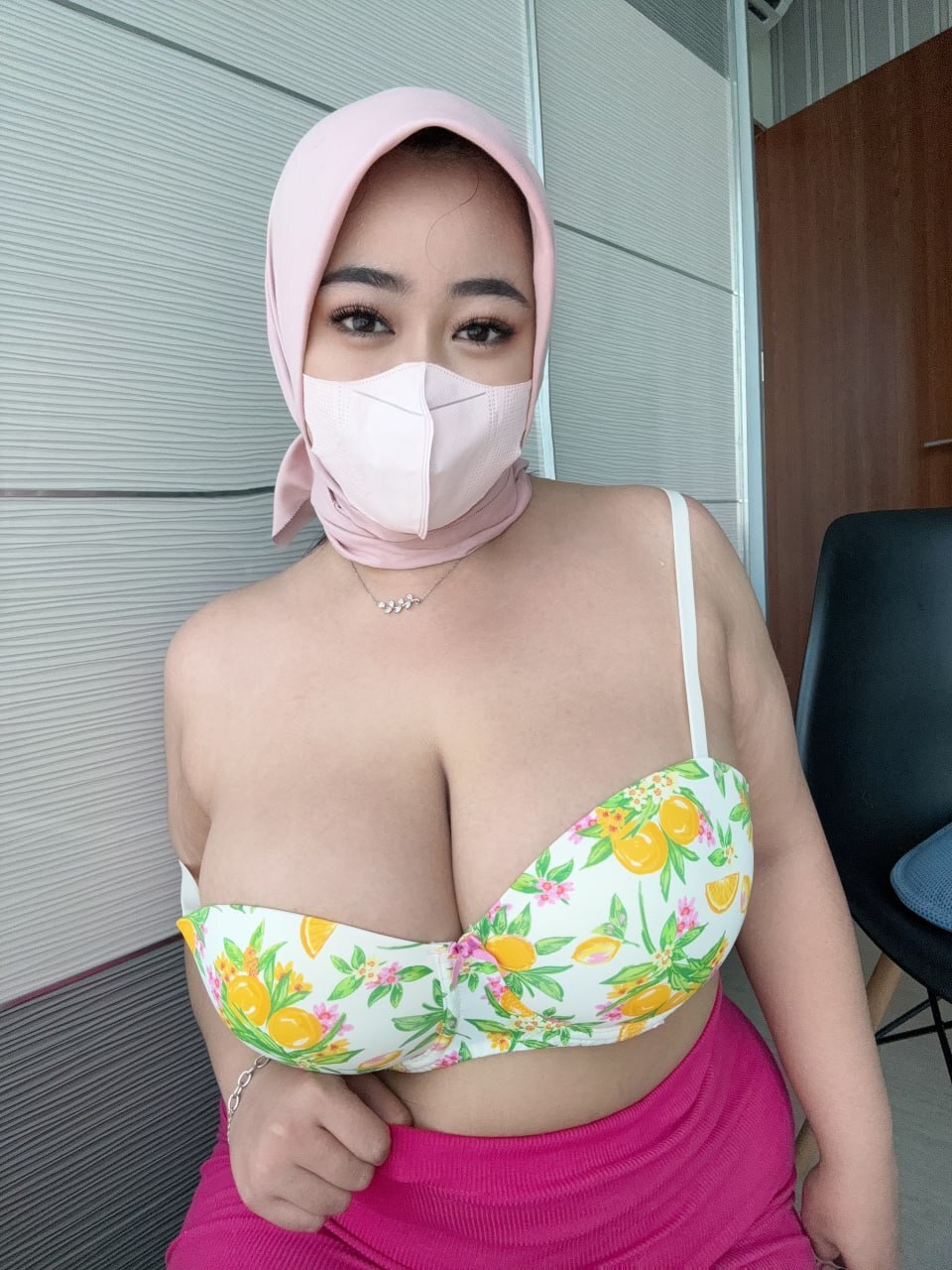 Solo girl with a tan and a face mask frees her big tits from a bra