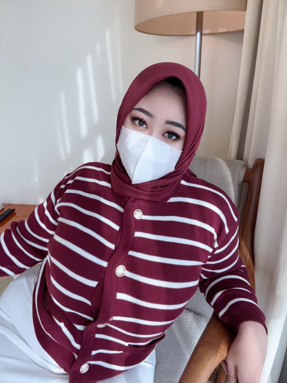 Solo girl takes selfies while wearing a surgical mask and hijab