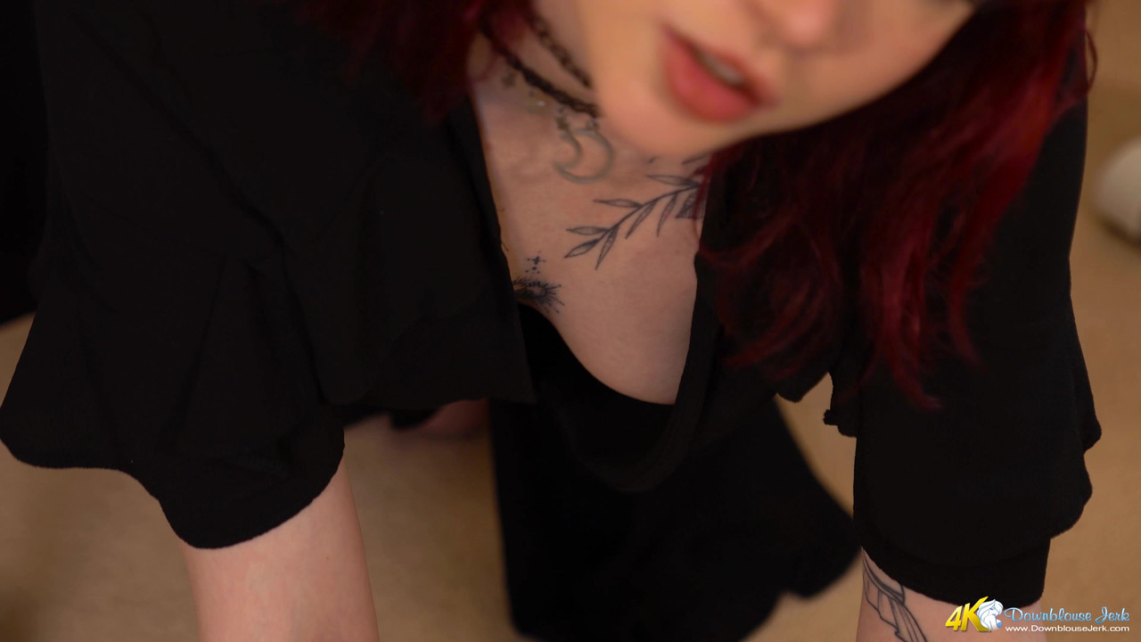 Amateur chick with red hair shows her cleavage while wearing a dark dress