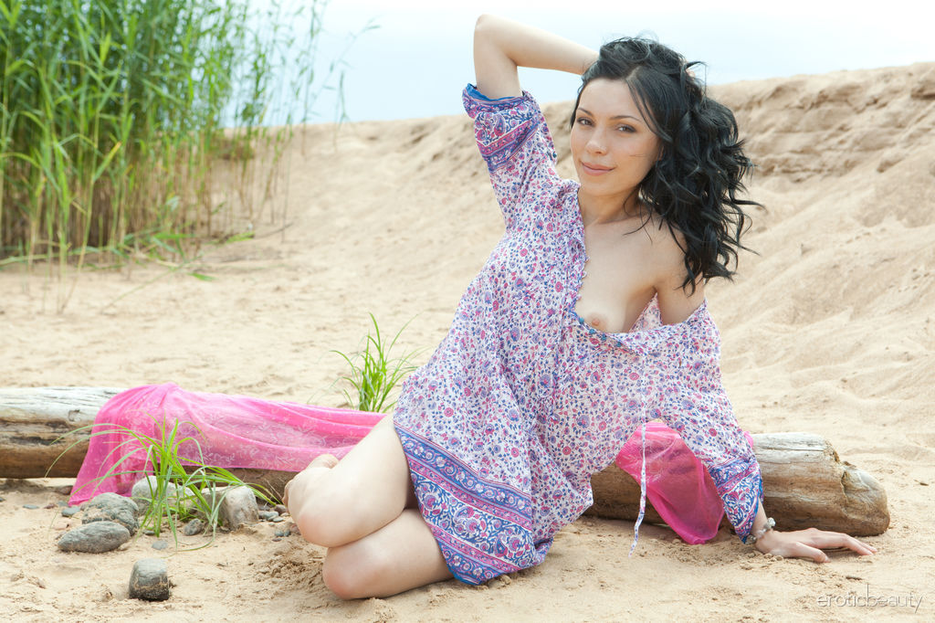 Brunette teen gets totally naked while visiting a sandy beach