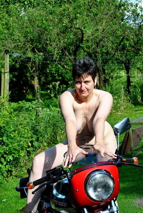 Older amateur HotMilf poses naked and red heels on a motorcycle in a yard