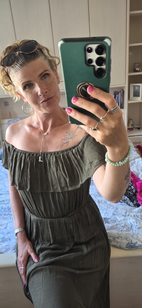Solo model with sexy eyes takes a selfie while wearing an asymmetrical dress