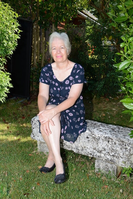 Old blonde lady disrobes on a garden swing before toying her pussy