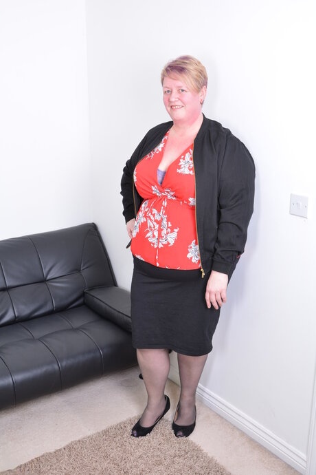 Obese amateur with a tattoo on her arm strips naked to masturbate on a sofa