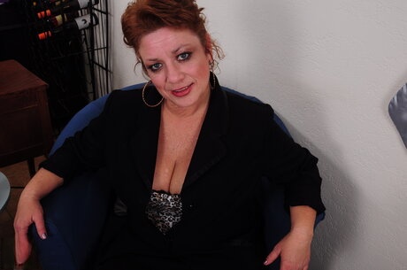 Older redhead gets naked on a chair before masturbating with a sex toy