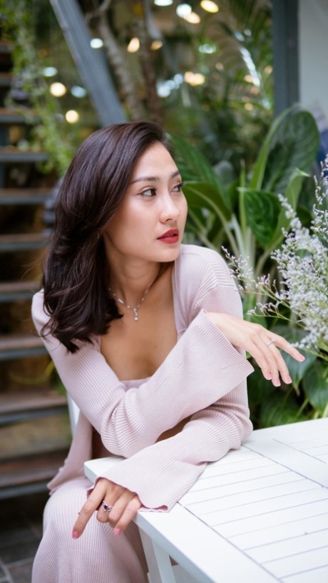 Attractive Asian babe smiles while posing seductively in public
