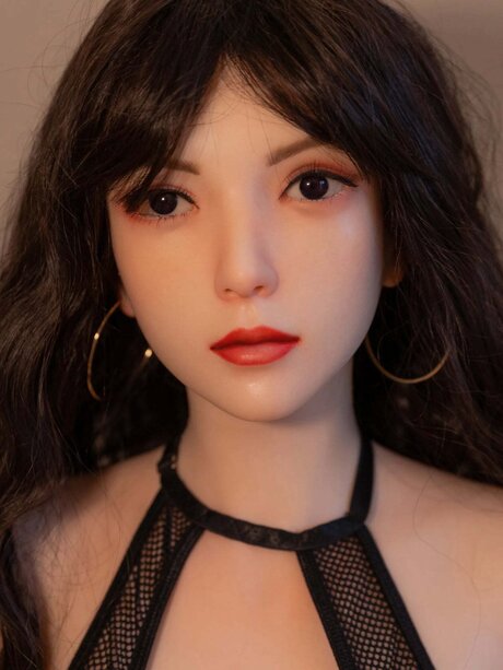 Sexy sex doll models a black mesh outfit in a tempting manner