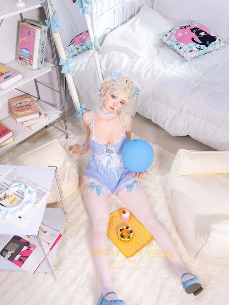 Cute sex doll with blue eyes undresses while serving a plate of food