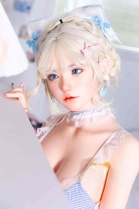 Cute blonde doll frees her big boobs from pretty lingerie in white stockings