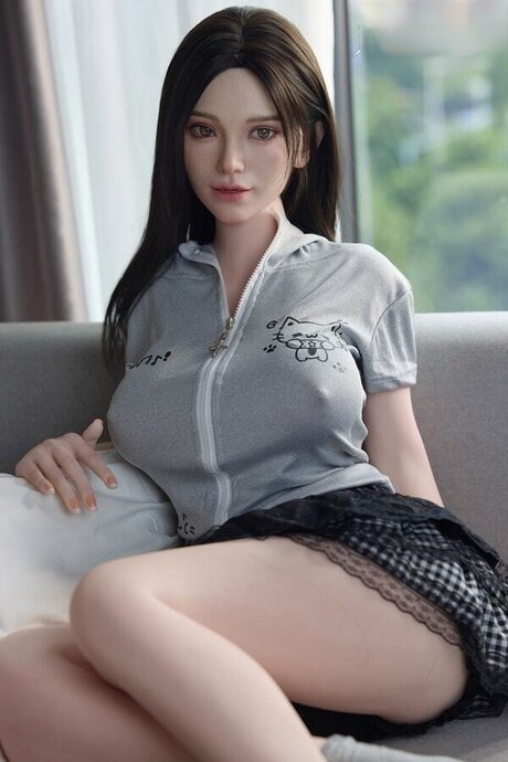 Dark haired girl undresses a sex doll before getting herself naked