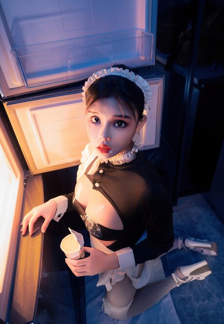Beautiful Asian maid spills ice cream on herself while serving a cup